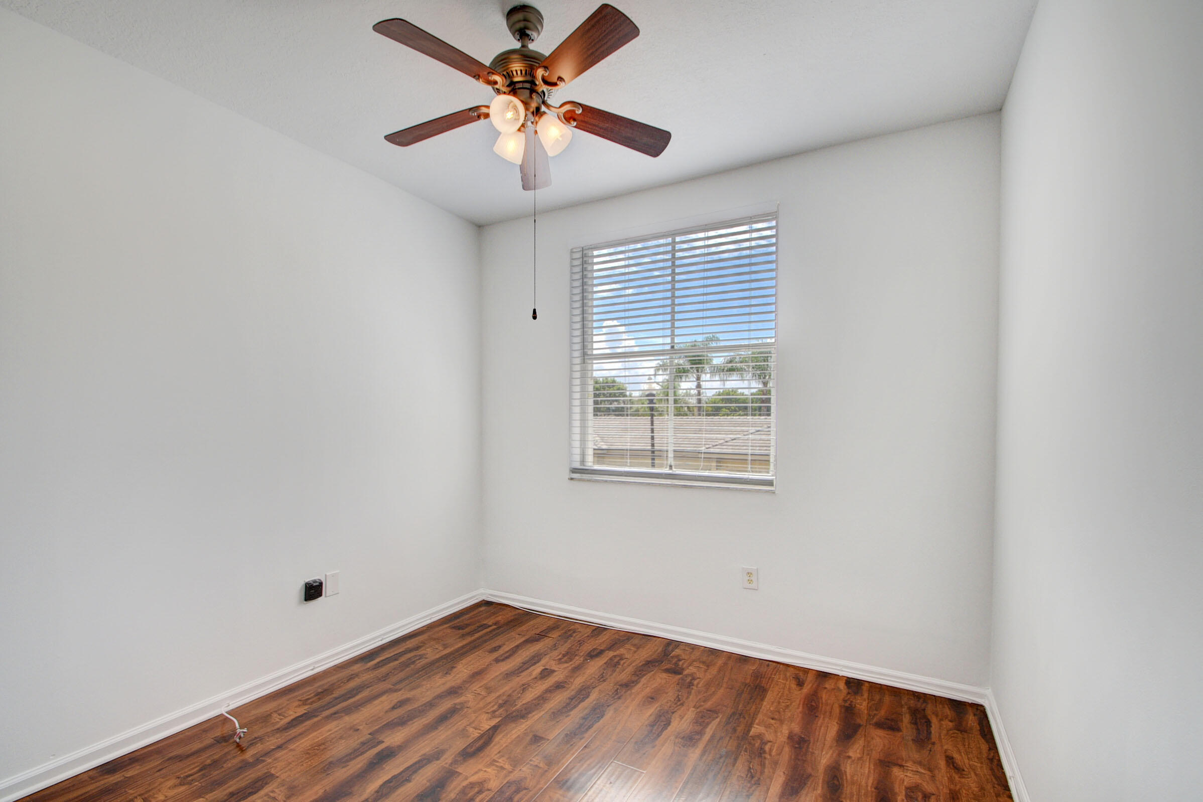 2020 Greenview Shores Boulevard, Unit 108 Wellington, FL 33414 - Photo 17 of 25 an empty room with windows and fan