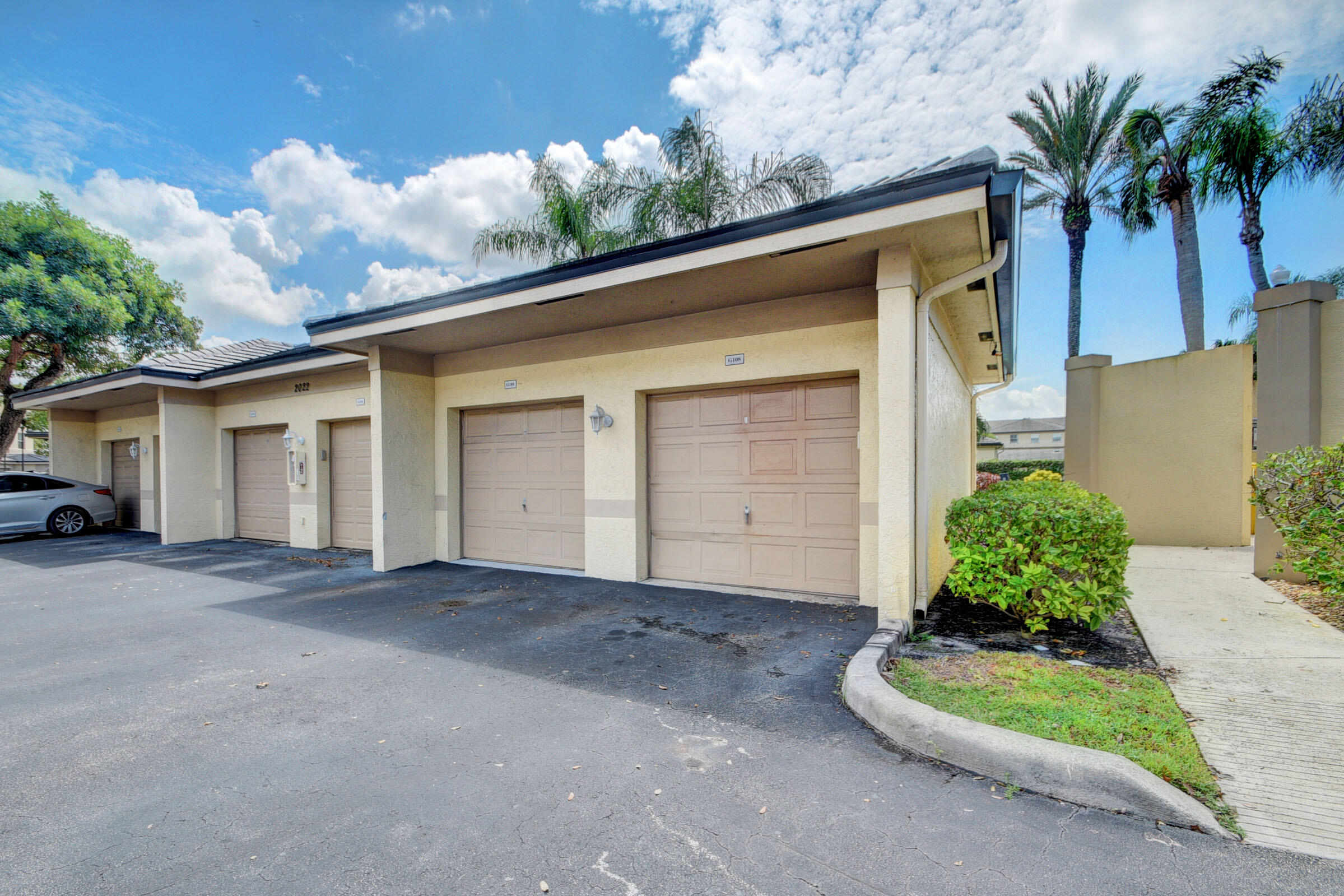 2020 Greenview Shores Boulevard, Unit 108 Wellington, FL 33414 - Photo 18 of 25 a house with a yard and garage
