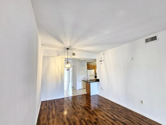 a view of empty room with wooden floor