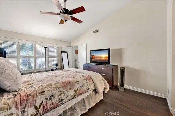 a bedroom with a bed and a flat tv screen on dresser