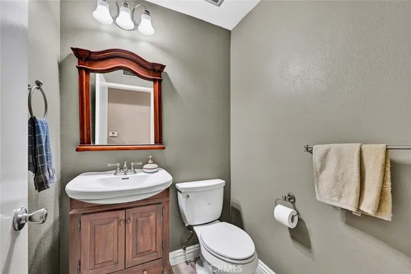 a bathroom with a granite countertop sink a toilet a mirror and shower