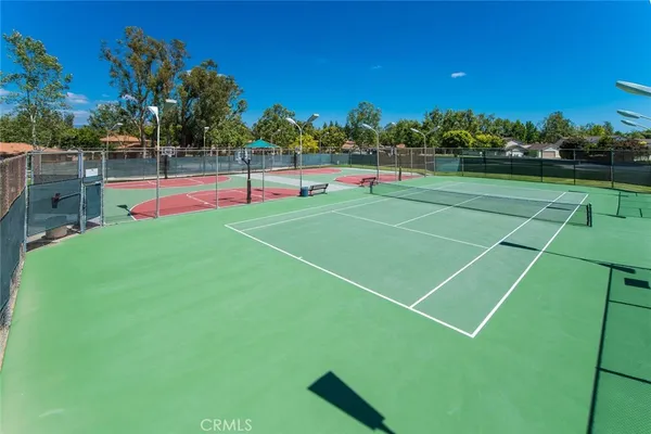 a view of a tennis ground with large trees