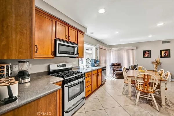 a kitchen with stainless steel appliances granite countertop a stove a sink and a microwave