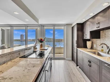 a bathroom with a granite countertop sink a toilet a mirror and shower