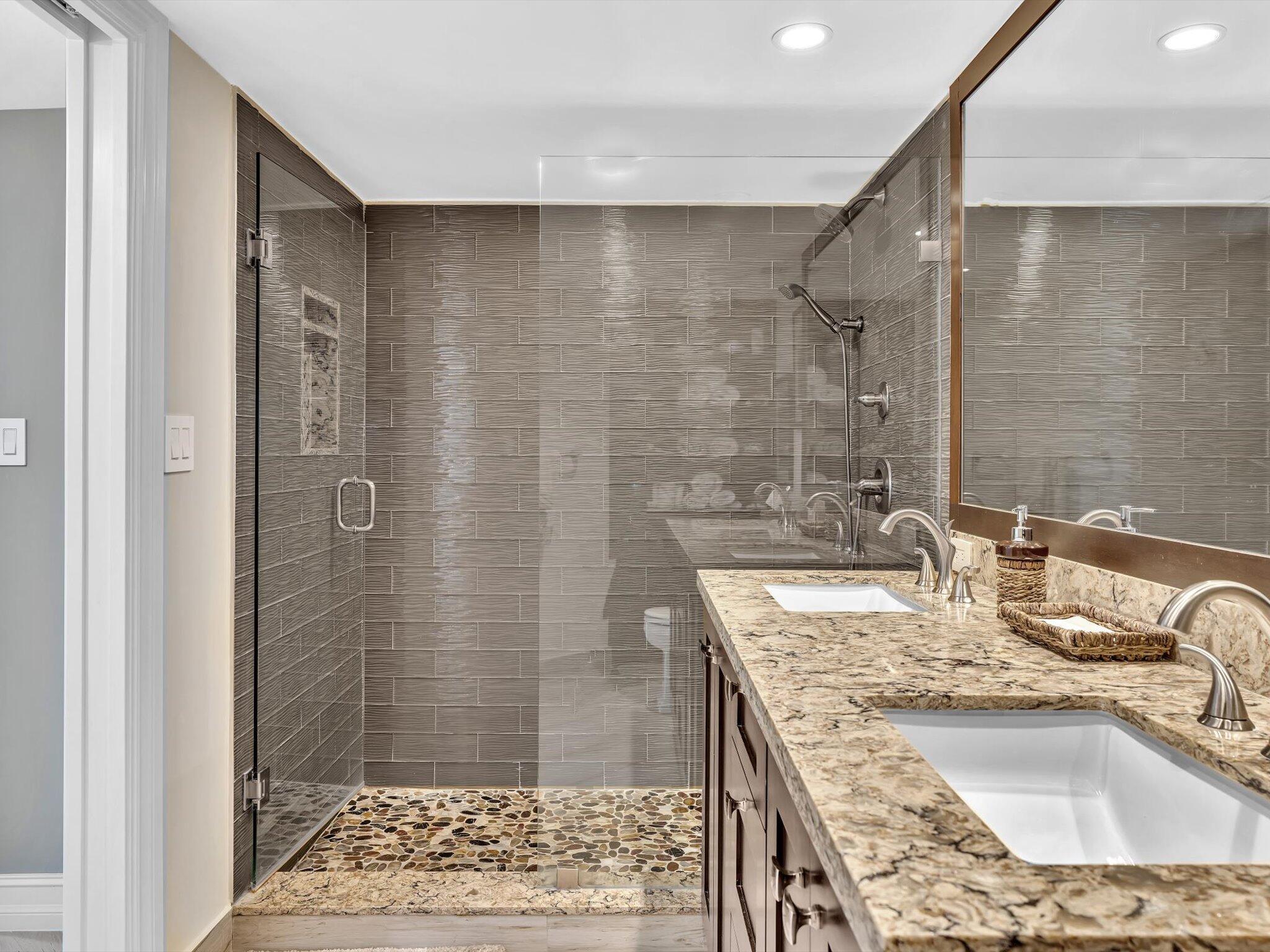500 South Ocean Boulevard, Unit 909 Boca Raton, FL 33432 - Photo 32 of 101 a bathroom with a granite countertop sink a mirror and shower