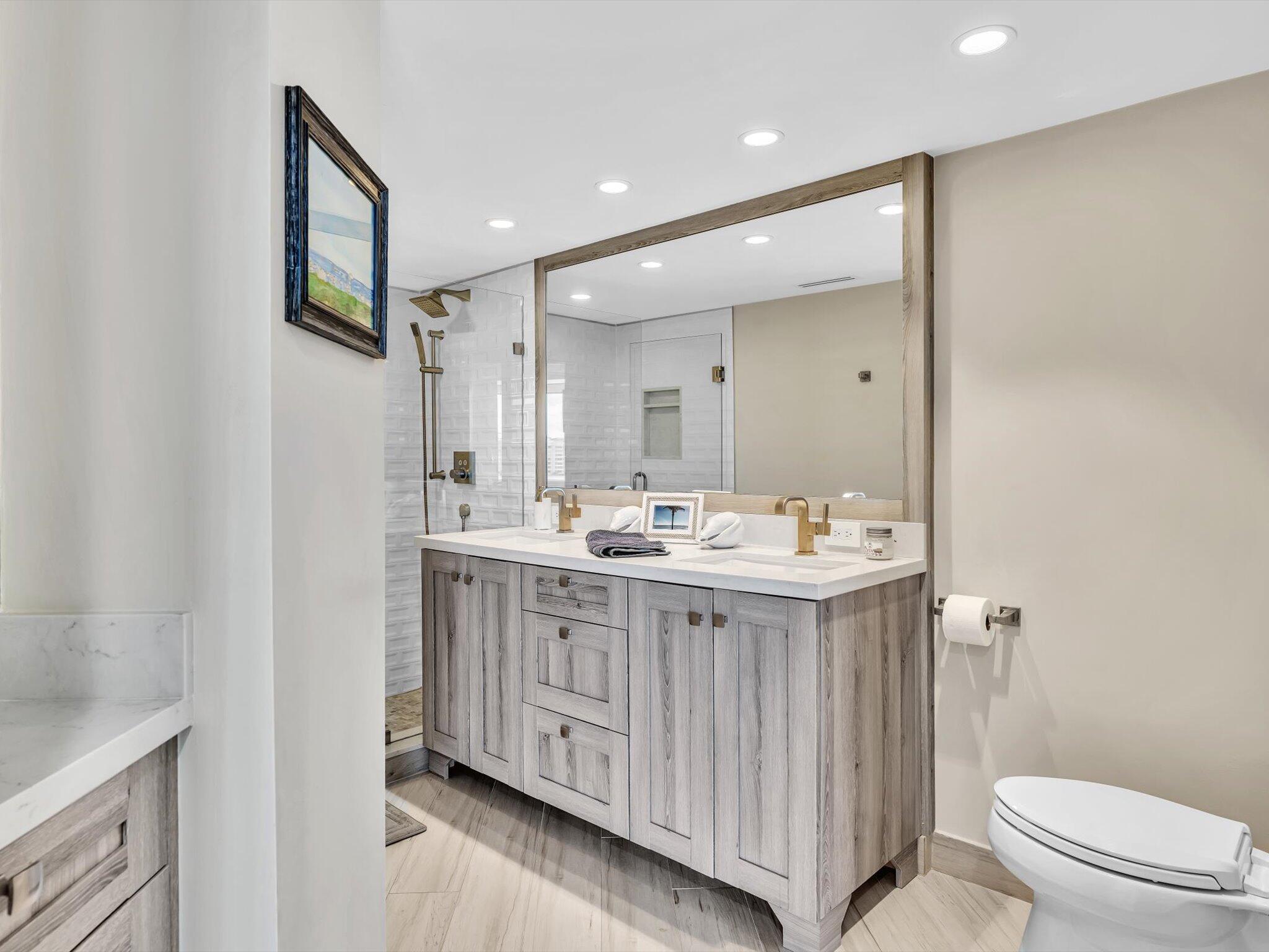 500 South Ocean Boulevard, Unit 909 Boca Raton, FL 33432 - Photo 40 of 101 a bathroom with a double vanity sink toilet and shower