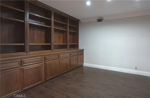 a large kitchen with kitchen island a stove a sink dishwasher and wooden cabinets with wooden floor