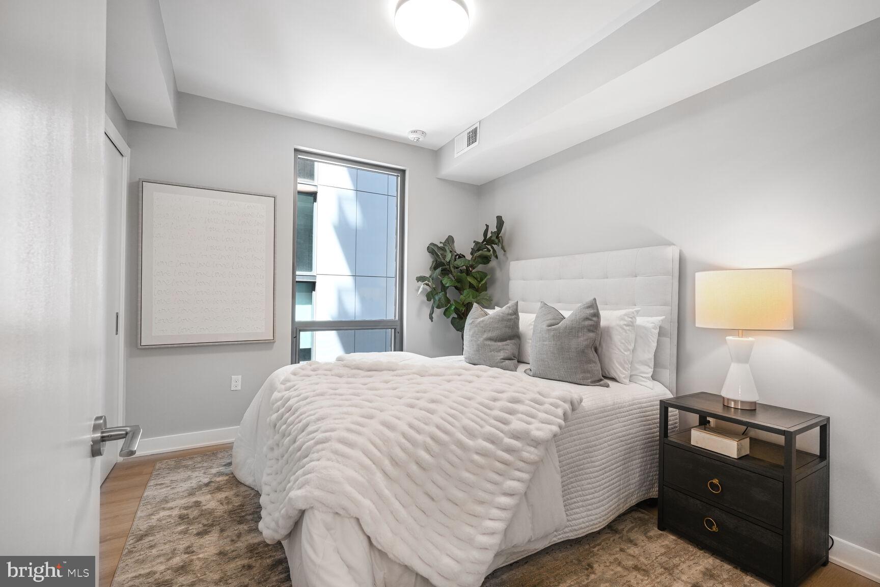 950 3rd Street Northwest, Unit 302 Washington, DC 20001 - Photo 31 of 37 a bedroom with a bed and lamp