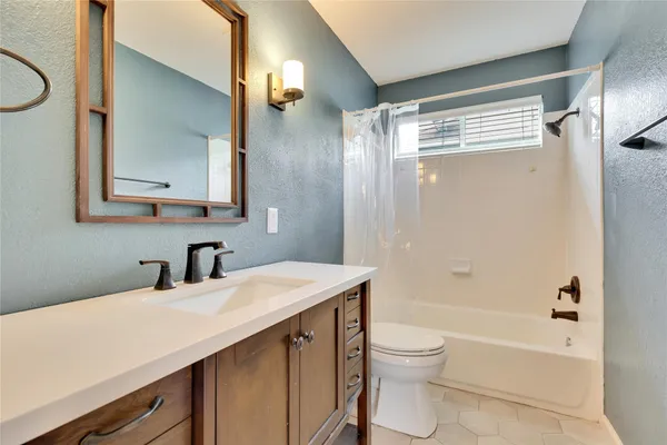 a bathroom with a granite countertop sink toilet and shower