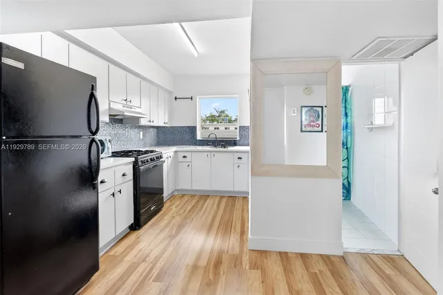 a kitchen with white cabinets and white appliances