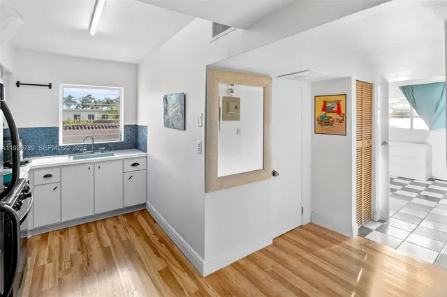 a view of a bedroom with a bed and wooden floor