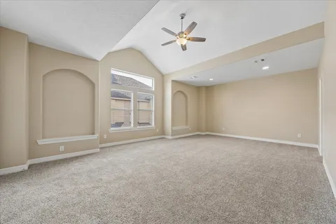 a spacious bedroom with a bed a chandelier and large window