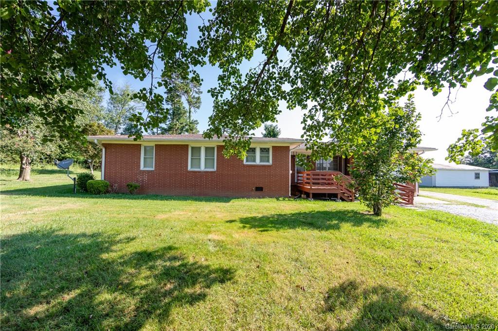 4480 Needmore Road Woodleaf, NC 27054 - Photo 3 of 15 a backyard of a house with plants and large tree