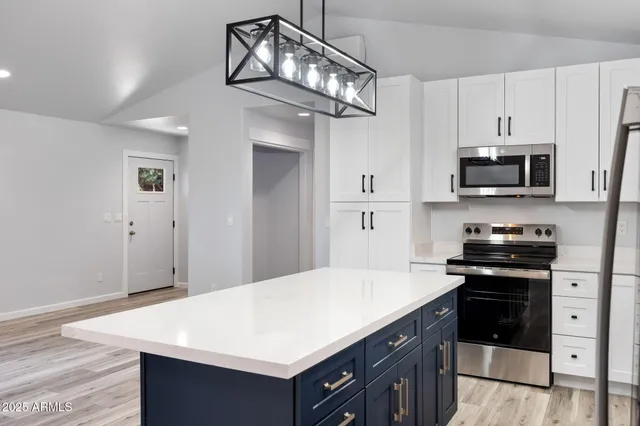 a kitchen with stainless steel appliances a stove sink microwave and cabinets