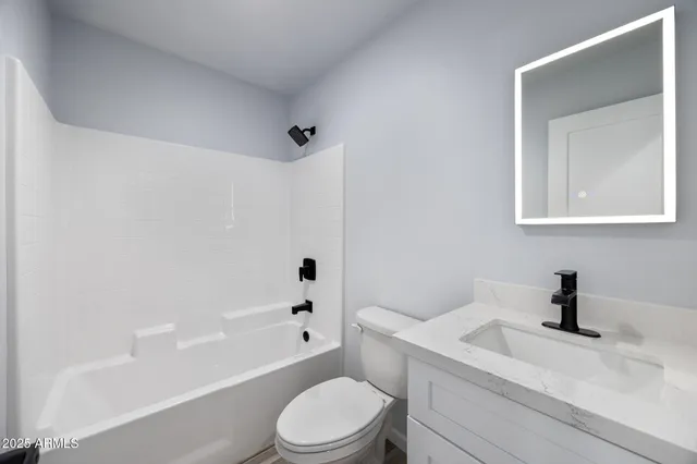 a white toilet sitting next to a bath tub