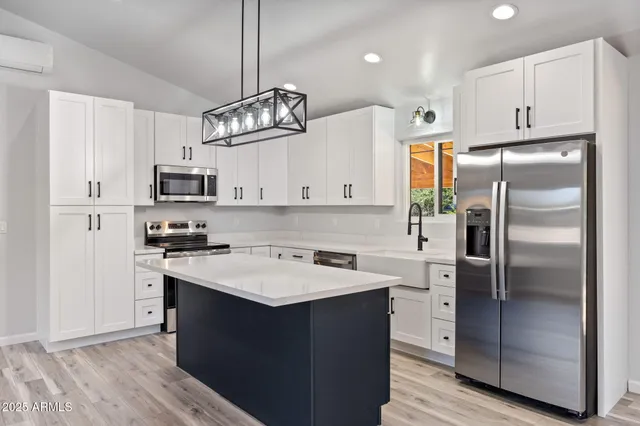 a kitchen with kitchen island granite countertop appliances cabinets a sink and a counter top space