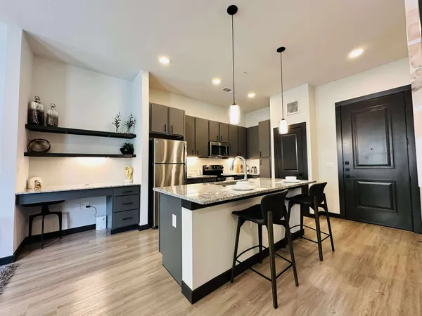 a kitchen with stainless steel appliances kitchen island granite countertop a sink counter space and cabinets