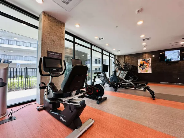 a kitchen with stainless steel appliances granite countertop a stove a sink dishwasher a refrigerator and a dining table with wooden floor