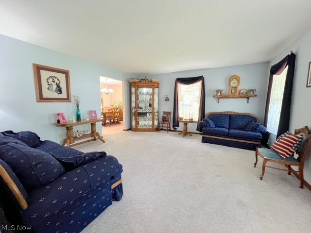 1349 Deer Hill Road Dennison, OH 44621 - Photo 8 of 36 Living room with carpet flooring, a wealth of natural light, and an inviting chandelier