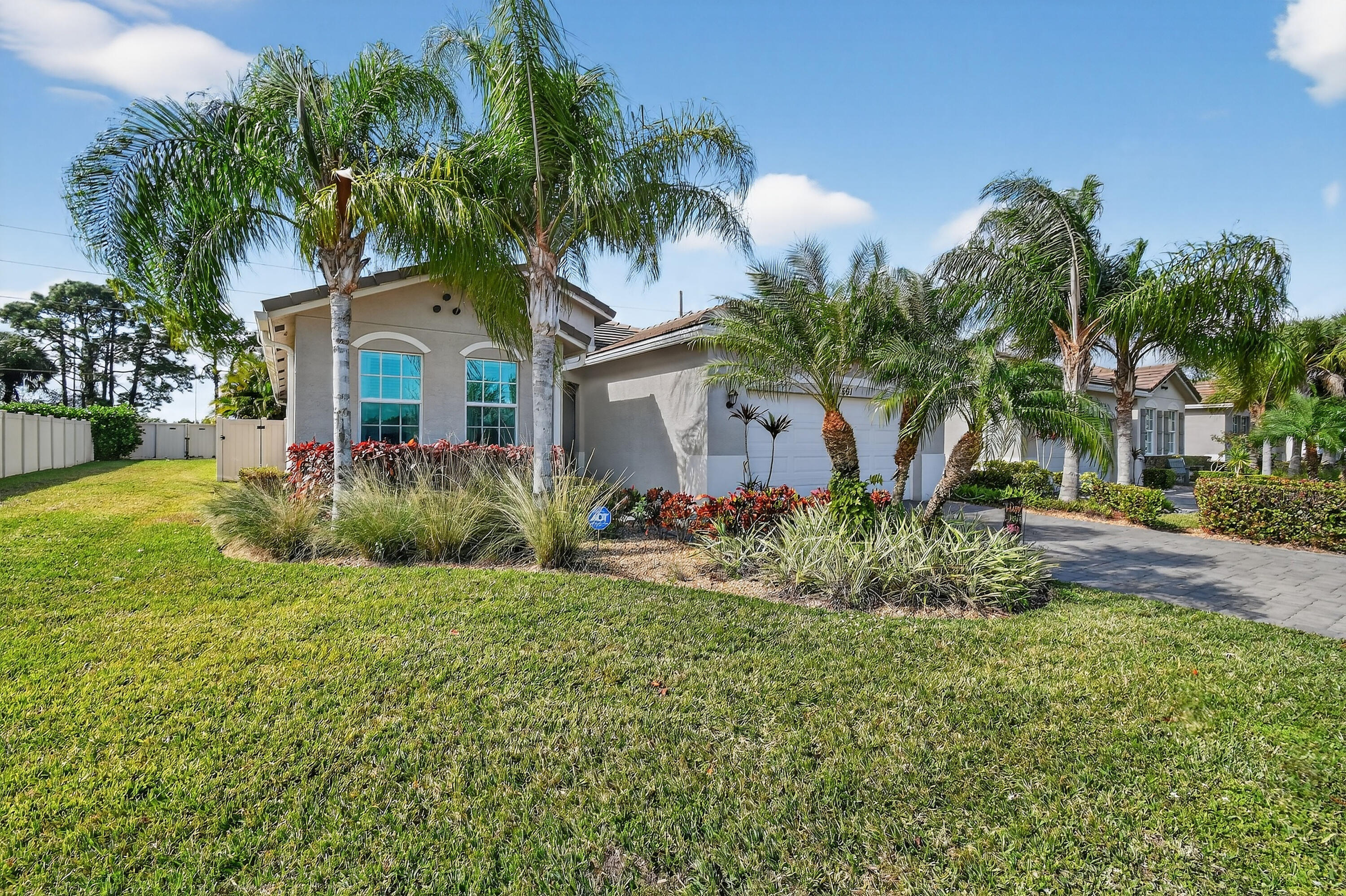 7561 Southwest Harbor Cove Drive Stuart, FL 34997 - Photo 1 of 62 a front view of a house with a garden