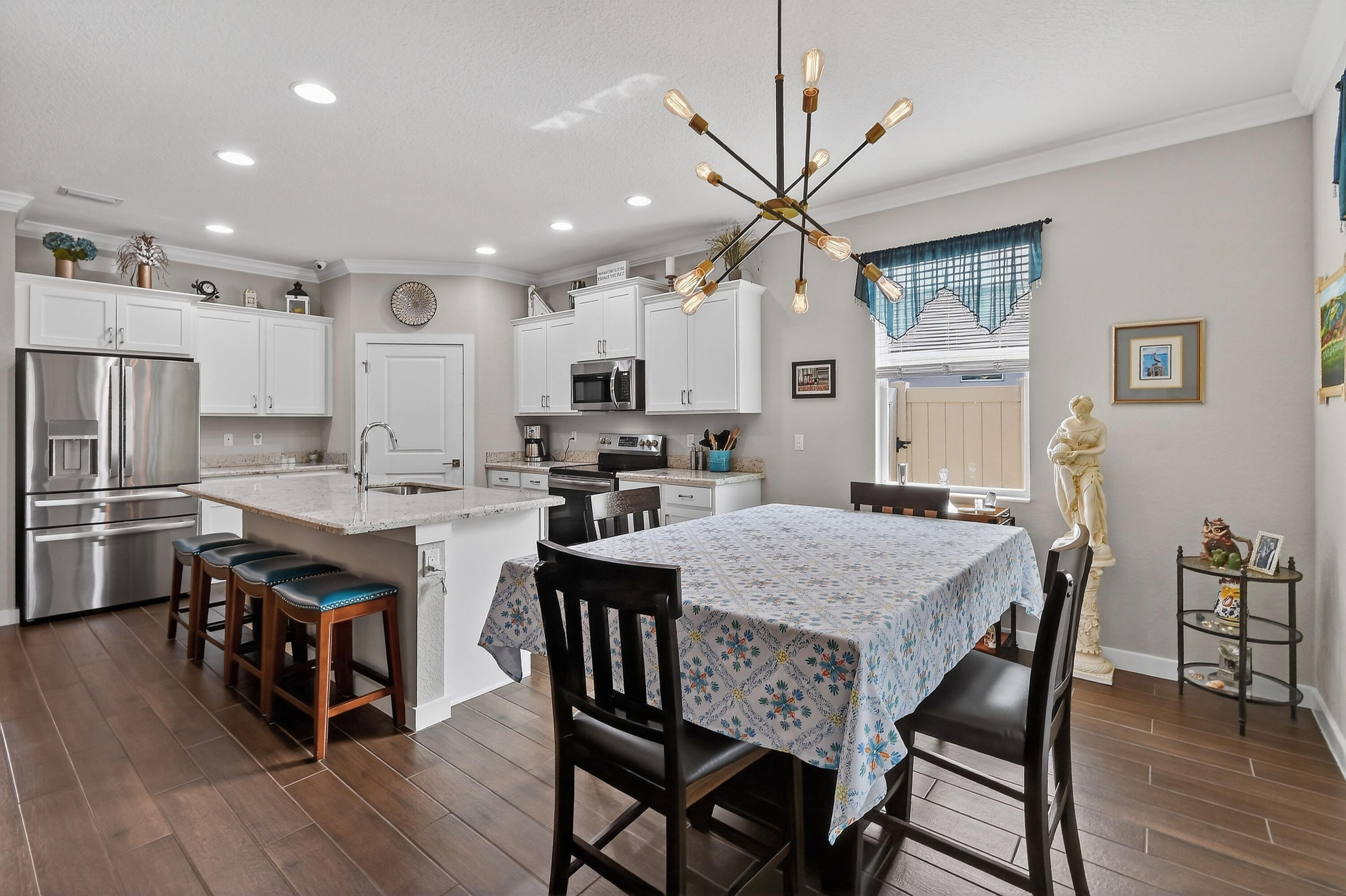 7561 Southwest Harbor Cove Drive Stuart, FL 34997 - Photo 20 of 62 a large kitchen with kitchen island a dining table and chairs