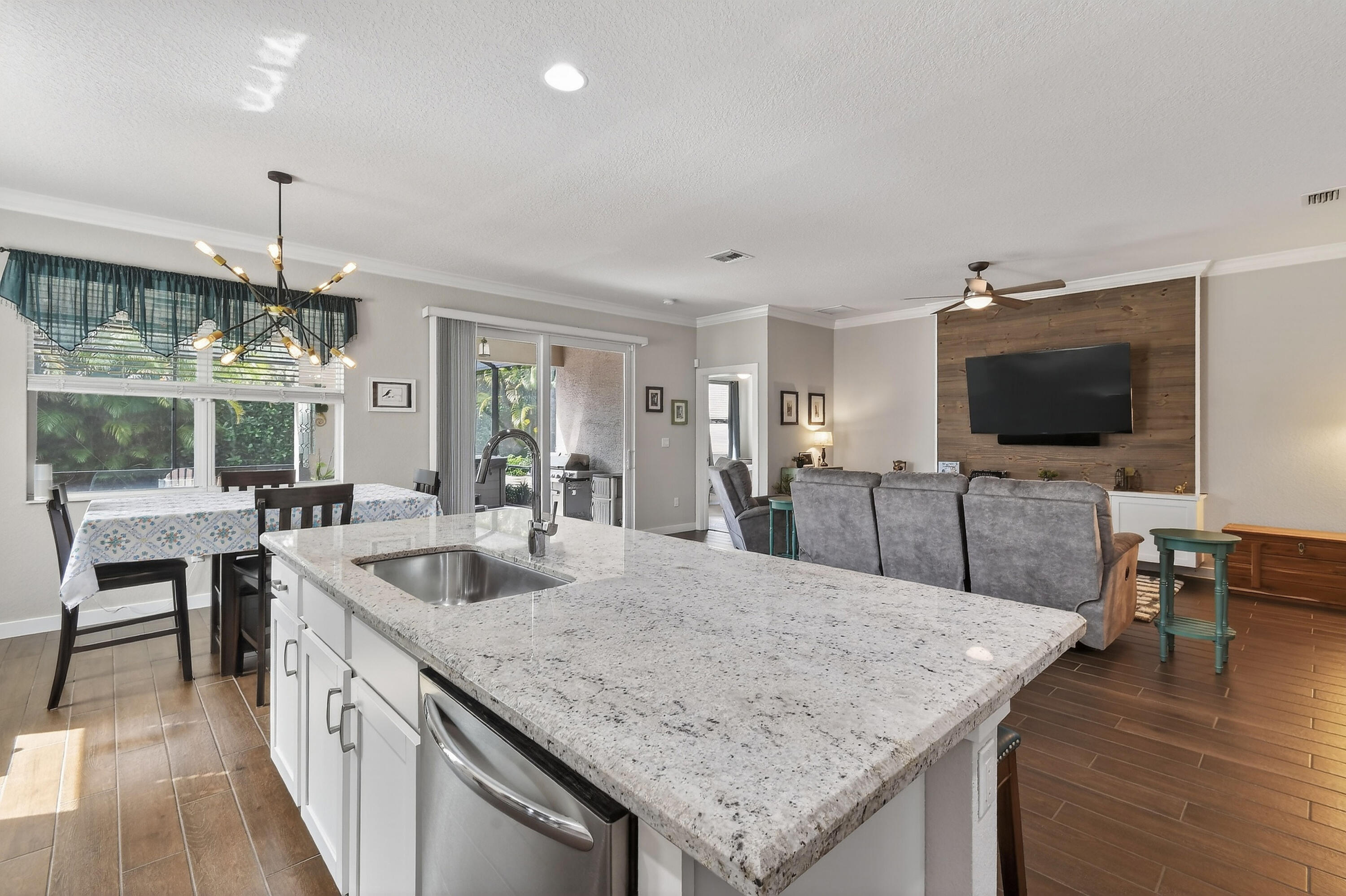 7561 Southwest Harbor Cove Drive Stuart, FL 34997 - Photo 29 of 62 a kitchen with granite countertop a sink and a wooden floor