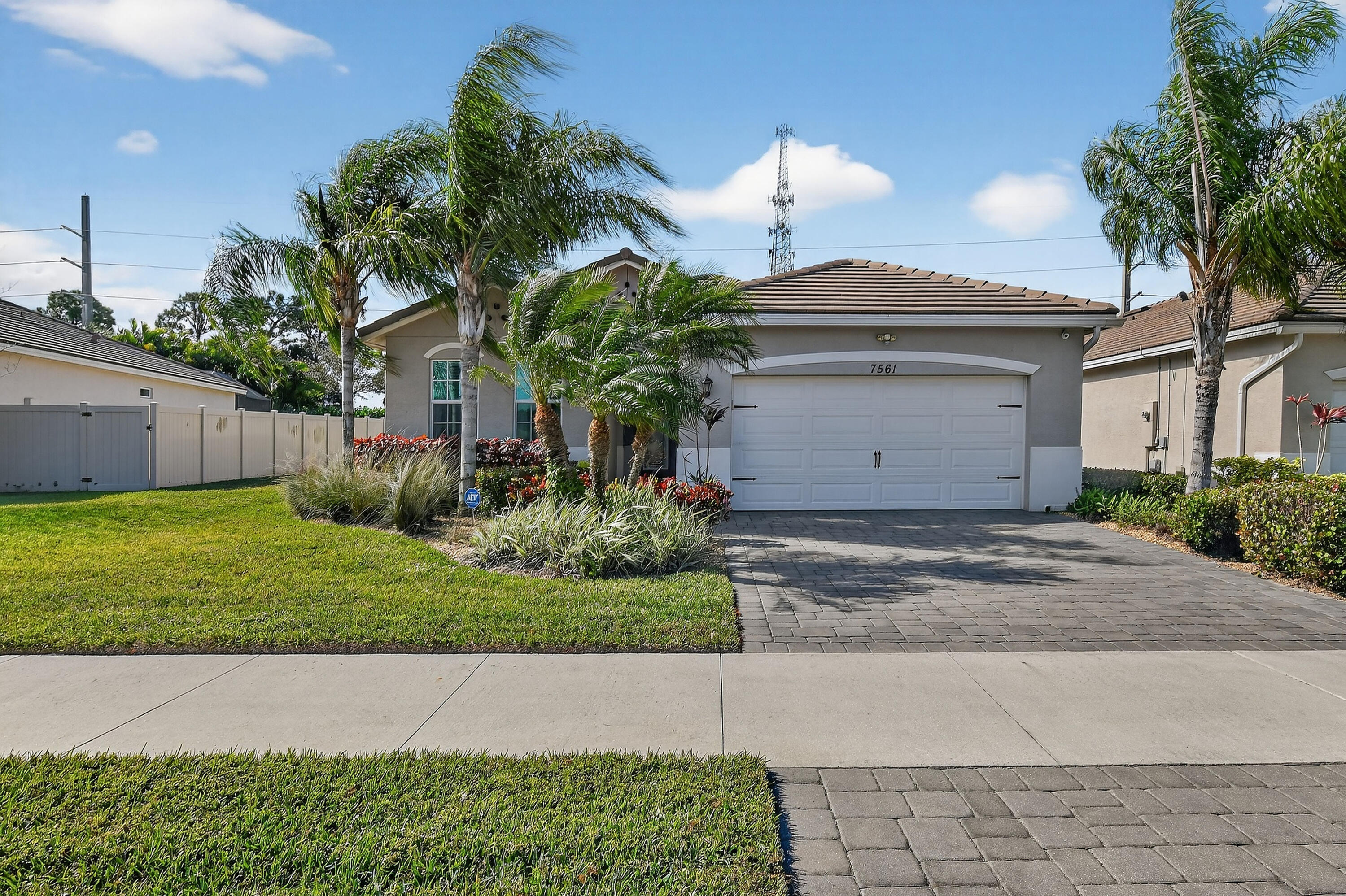 7561 Southwest Harbor Cove Drive Stuart, FL 34997 - Photo 3 of 62 a front view of a house with garden