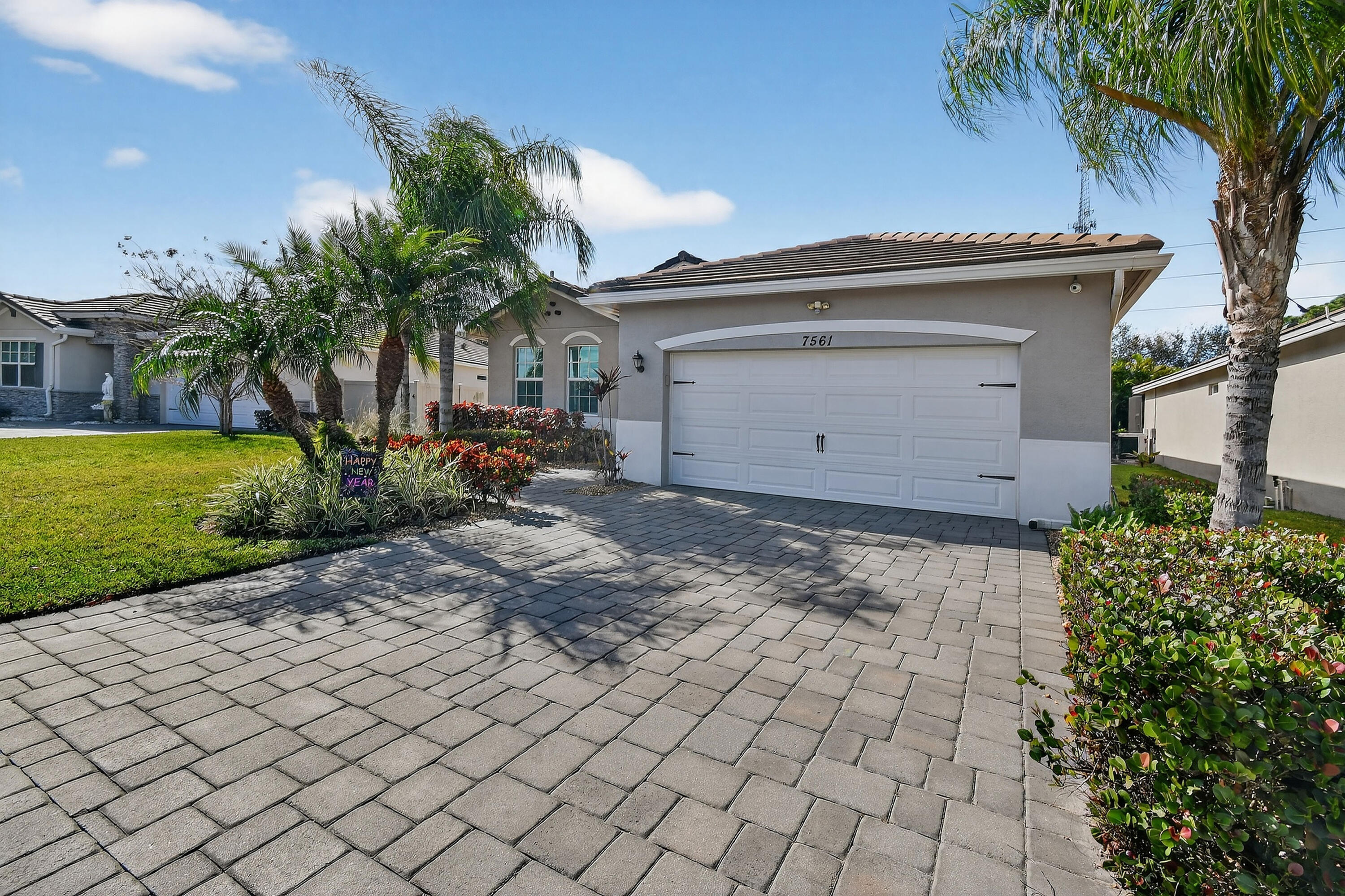 7561 Southwest Harbor Cove Drive Stuart, FL 34997 - Photo 4 of 62 a front view of a house with garden