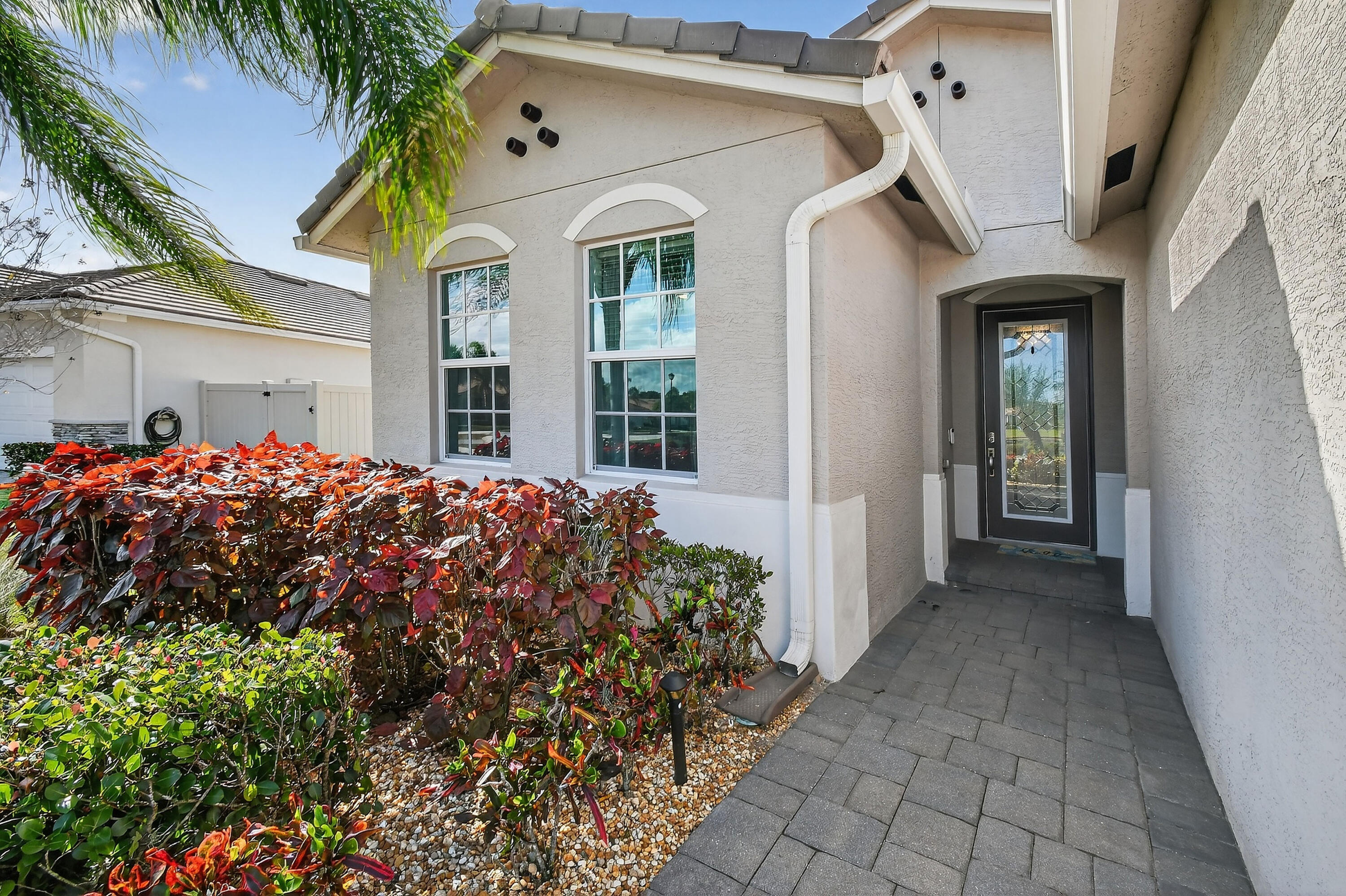 7561 Southwest Harbor Cove Drive Stuart, FL 34997 - Photo 6 of 62 a front view of a house with a lots of flowers