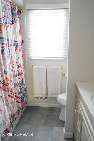 a bathroom with a toilet and a shower curtain