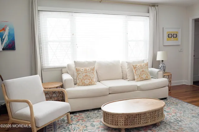 a living room with furniture wooden floor and a window