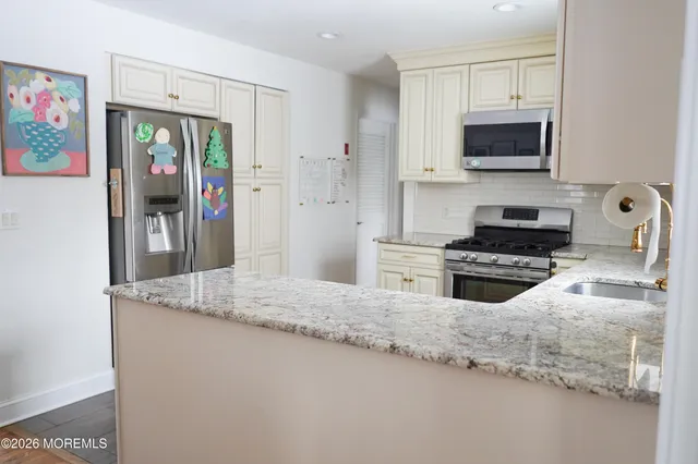 a kitchen with granite countertop a refrigerator and a sink