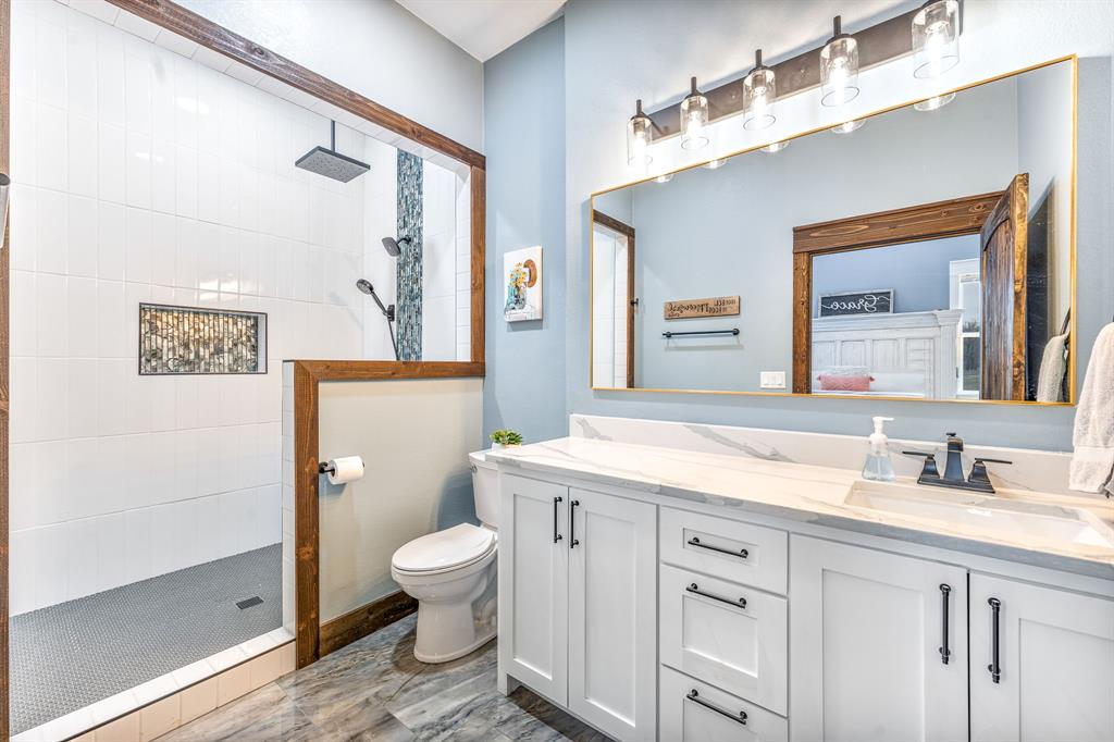 239 32507th Road Paris, TX 75460 - Photo 35 of 40 a spacious bathroom with a granite countertop sink a toilet and a mirror