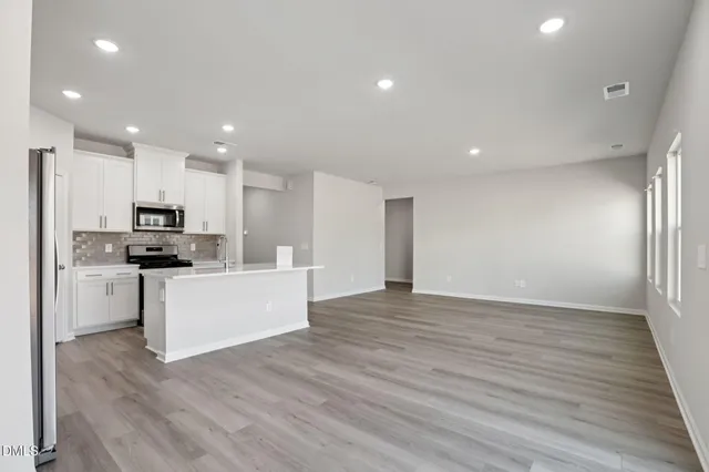 a view of kitchen with granite countertop cabinets and refrigerator