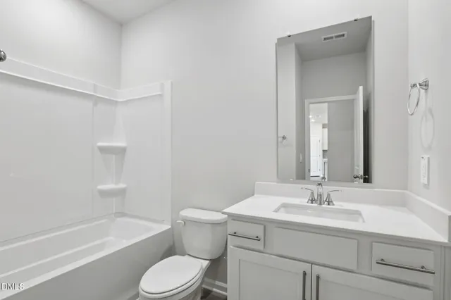 a bathroom with a sink toilet vanity and tub