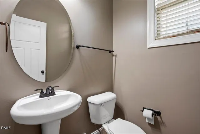 a bathroom with a sink a toilet and mirror