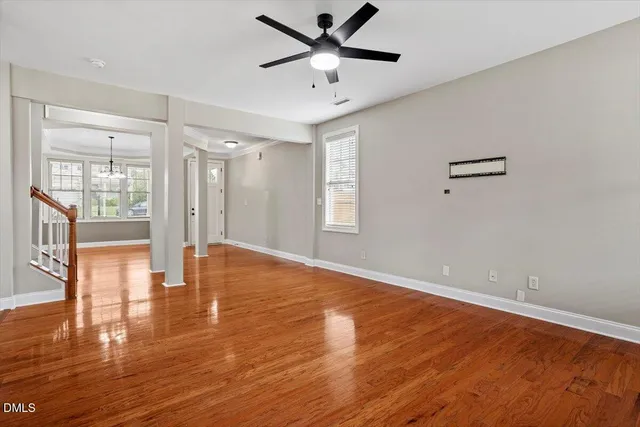 a view of an empty room with window and wooden floor