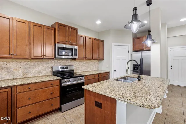 a kitchen with granite countertop a sink cabinets and stainless steel appliances