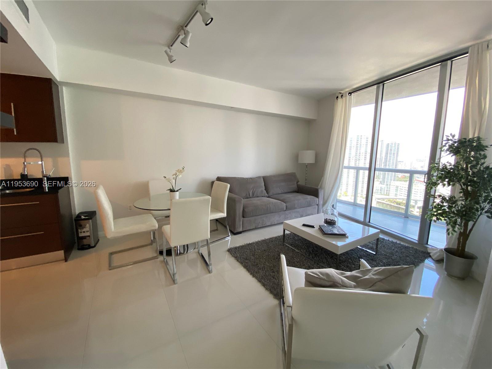 465 Brickell Avenue, Unit 3004 Miami, FL 33131 - Photo 4 of 17 a living room with furniture and a flat screen tv