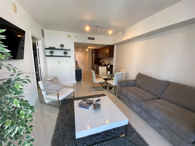 a living room with furniture and a potted plant