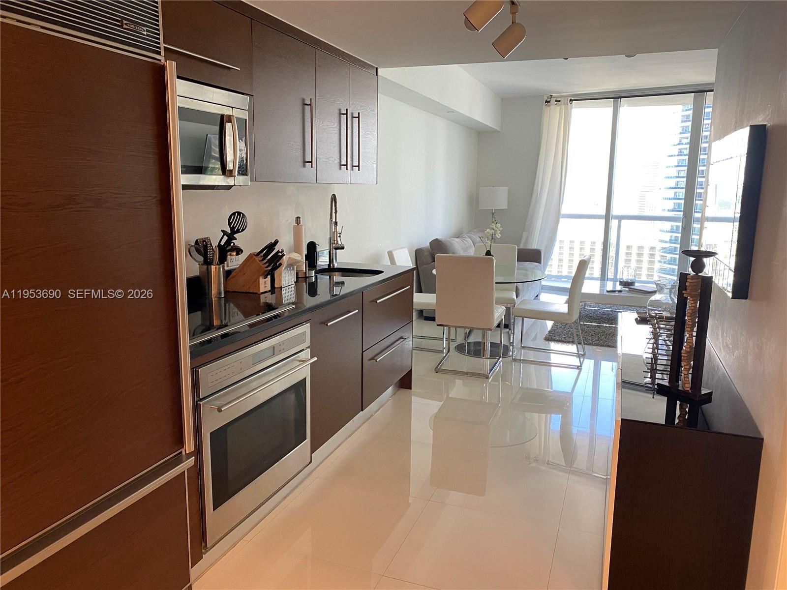 465 Brickell Avenue, Unit 3004 Miami, FL 33131 - Photo 7 of 17 a kitchen with stainless steel appliances kitchen island granite countertop a refrigerator and cabinets