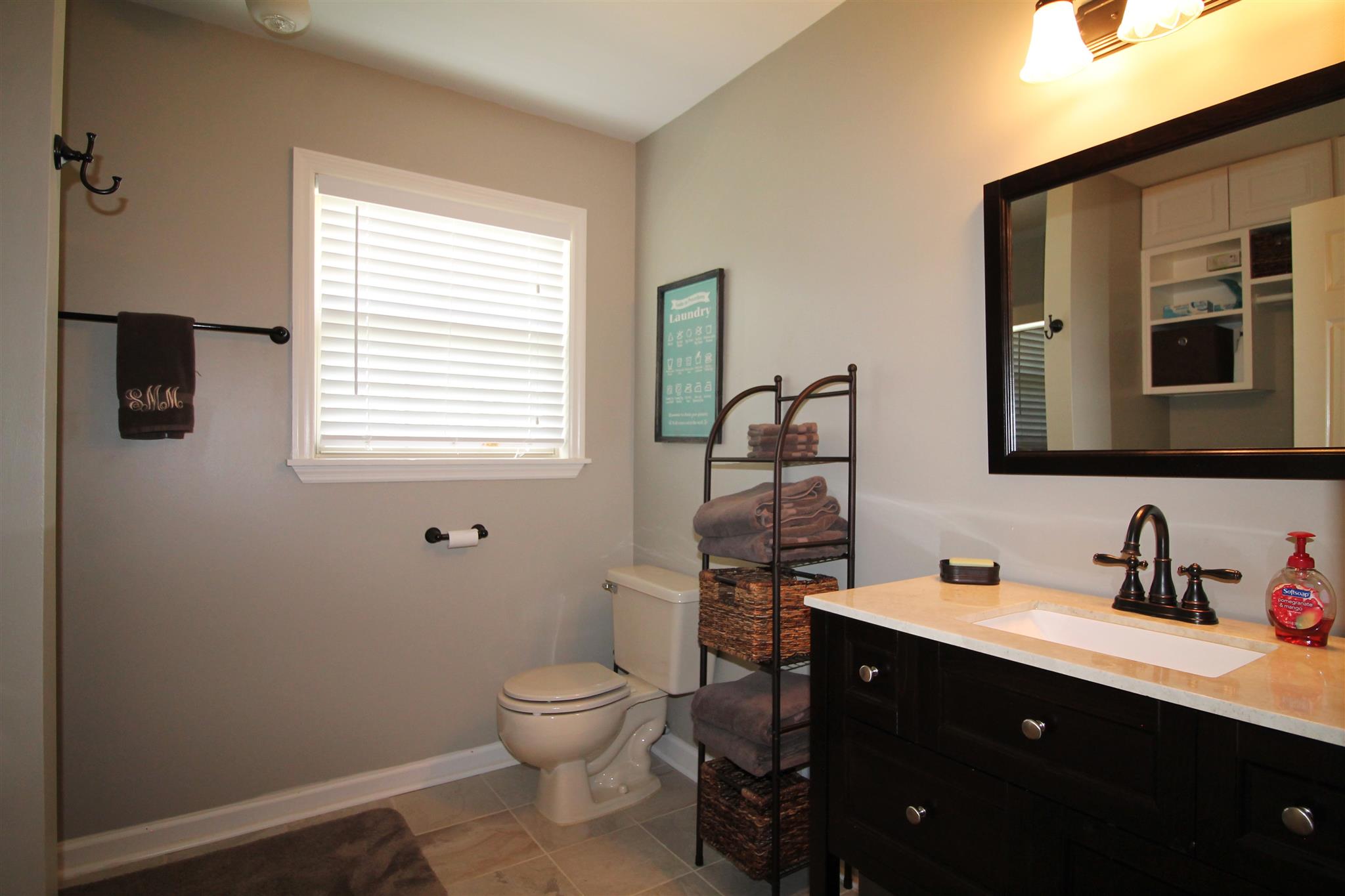 1539 West Harpeth Road Franklin, TN 37064 - Photo 23 of 30 a bathroom with a toilet sink a mirror and vanity