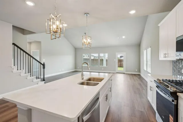 a kitchen with a stove a sink and a refrigerator