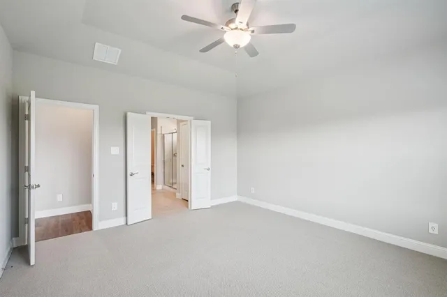 an empty room with fan and entrance