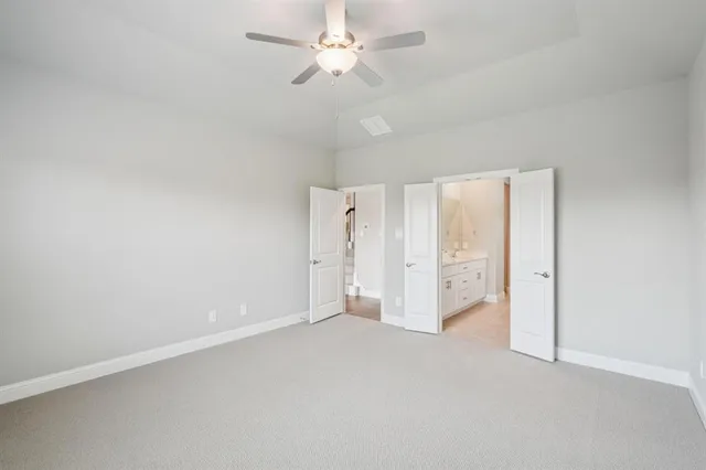 an empty room with a ceiling fan and a window
