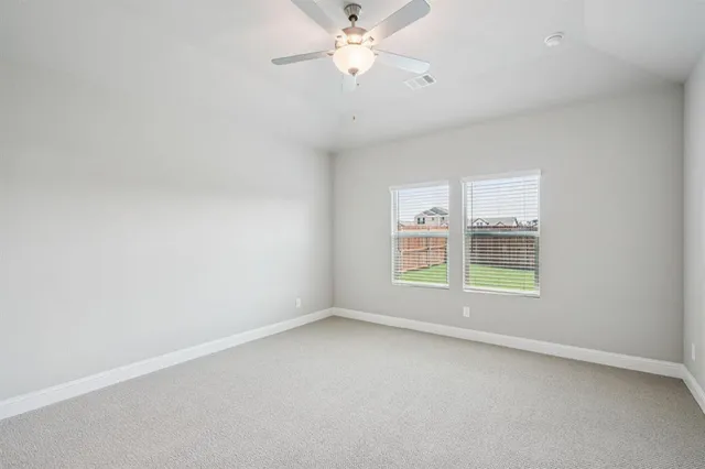 an empty room with a window and a fan