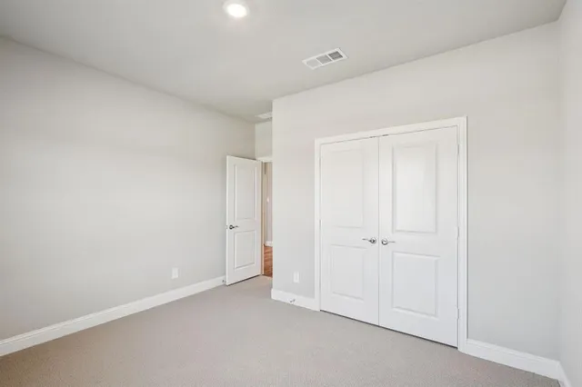 an empty room with white cabinet and closet