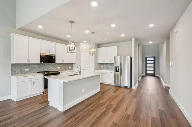 a kitchen with stainless steel appliances kitchen island granite countertop a stove and a refrigerator