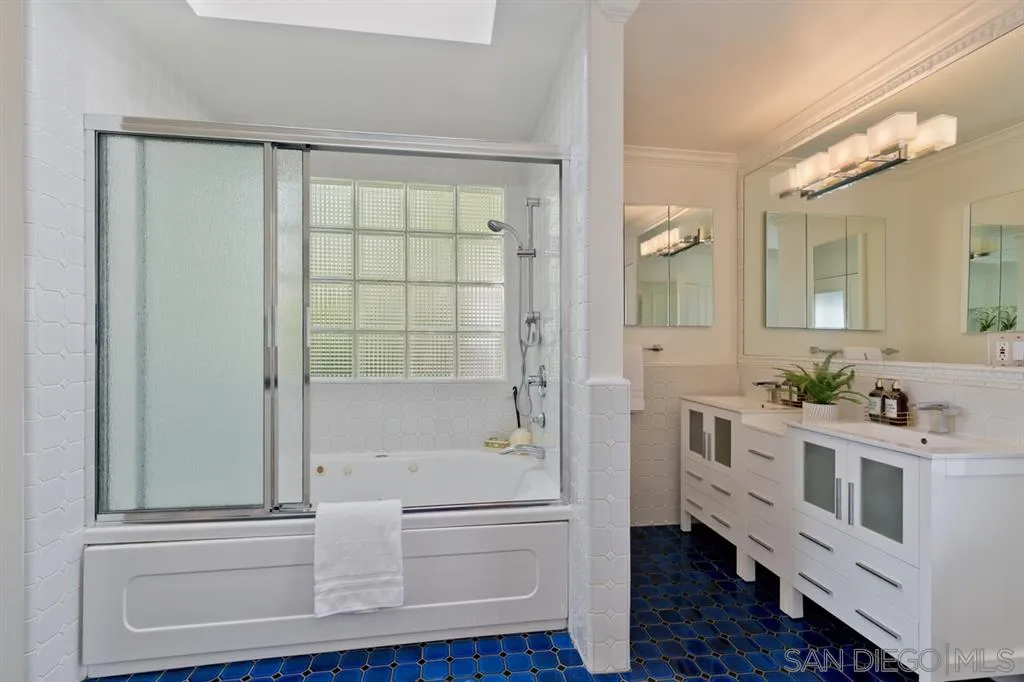 13606 Acorn Patch Lane Poway, CA 92064 - Photo 22 of 25 a bathroom with a double vanity sink a mirror and a bathtub