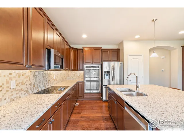 a kitchen with stainless steel appliances granite countertop plenty wooden cabinets counter space a sink and a refrigerator